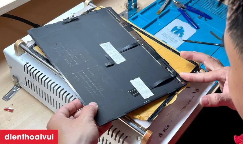 Kỹ thuật viên thực hiện lắp đặt tấm nền mới vào khung máy